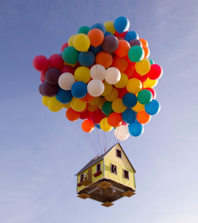 imagen de una casa volando a través de unos globos de colores 