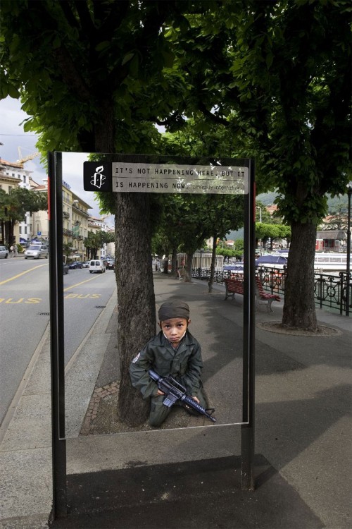 niño con un arma de asalto en la calle