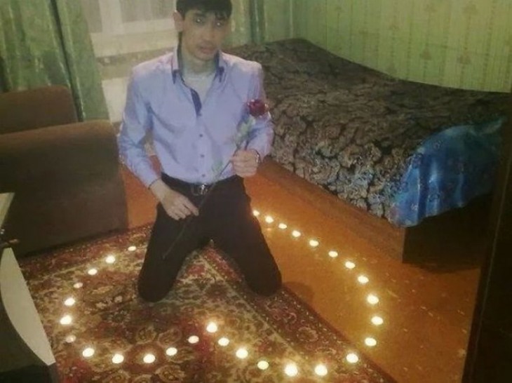 Un hombre enamorado dentro de un corazón hecho de velas