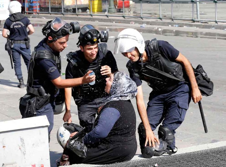 Policías ayudan a mujer a limpiar sus ojos del gas lacrimógeno, Turquía 2013