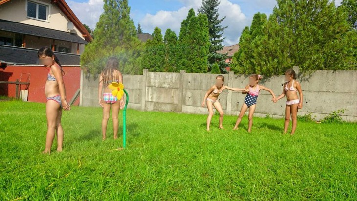 niñas jugando a mojarse en su jardín