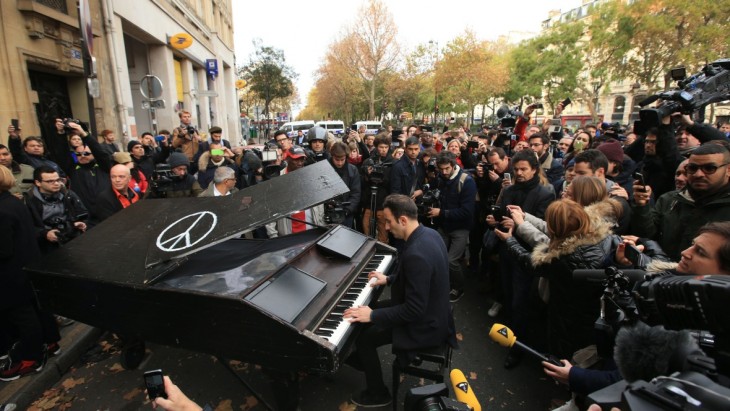 Hombre toca imagine de john lennon después del atentado en París en noviembre