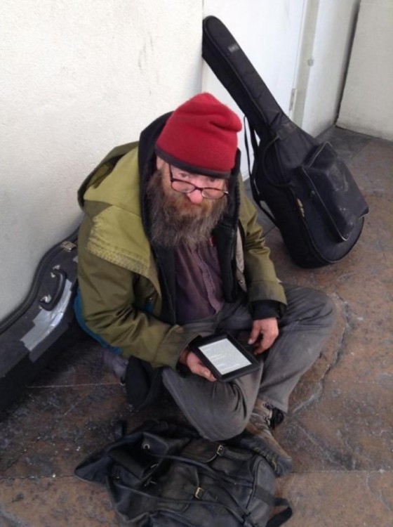 hombre sin hogar con tableta electrónica con cientos de novelas