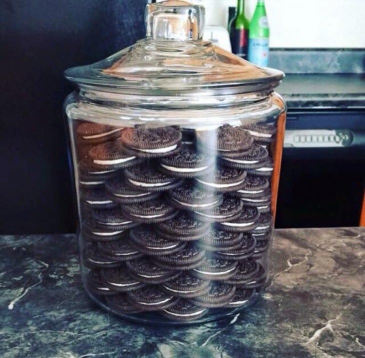 Frasco de vidrio con galletas oreo ordenadas dentro 