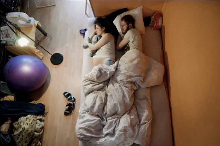 un hombre que cuida de su esposa embarazada mientras están durmiendo