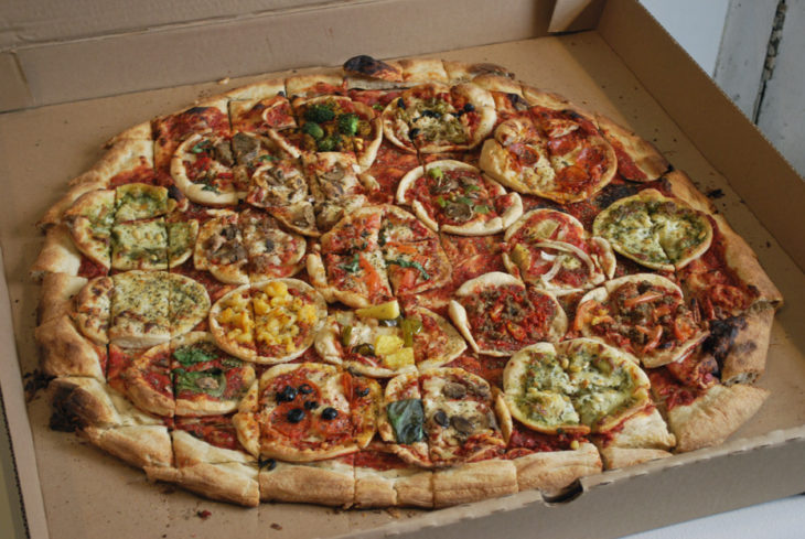 Una pizza grande con muchas pizzas chicas en su interior