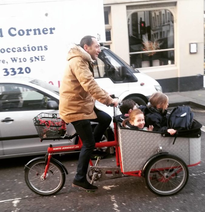 niños en una bicicleta que maneja su papá