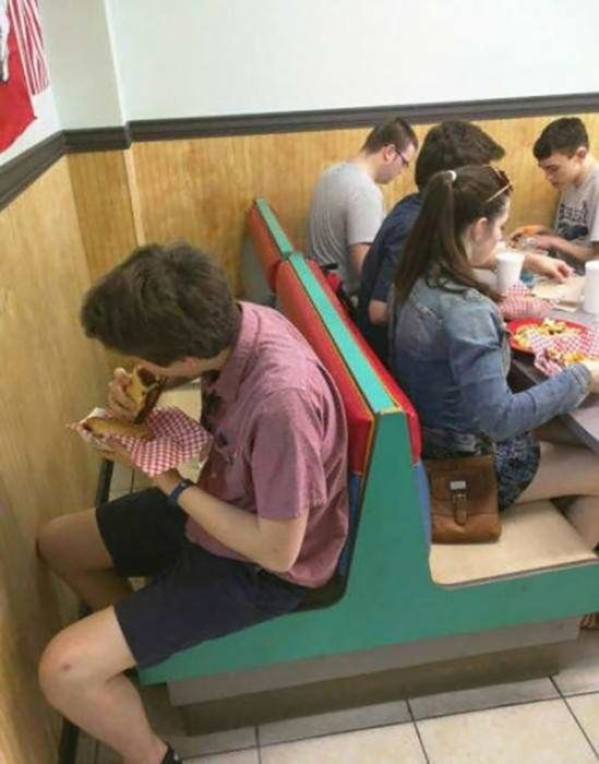 chico comiendo un burrito en una silla contra la pared